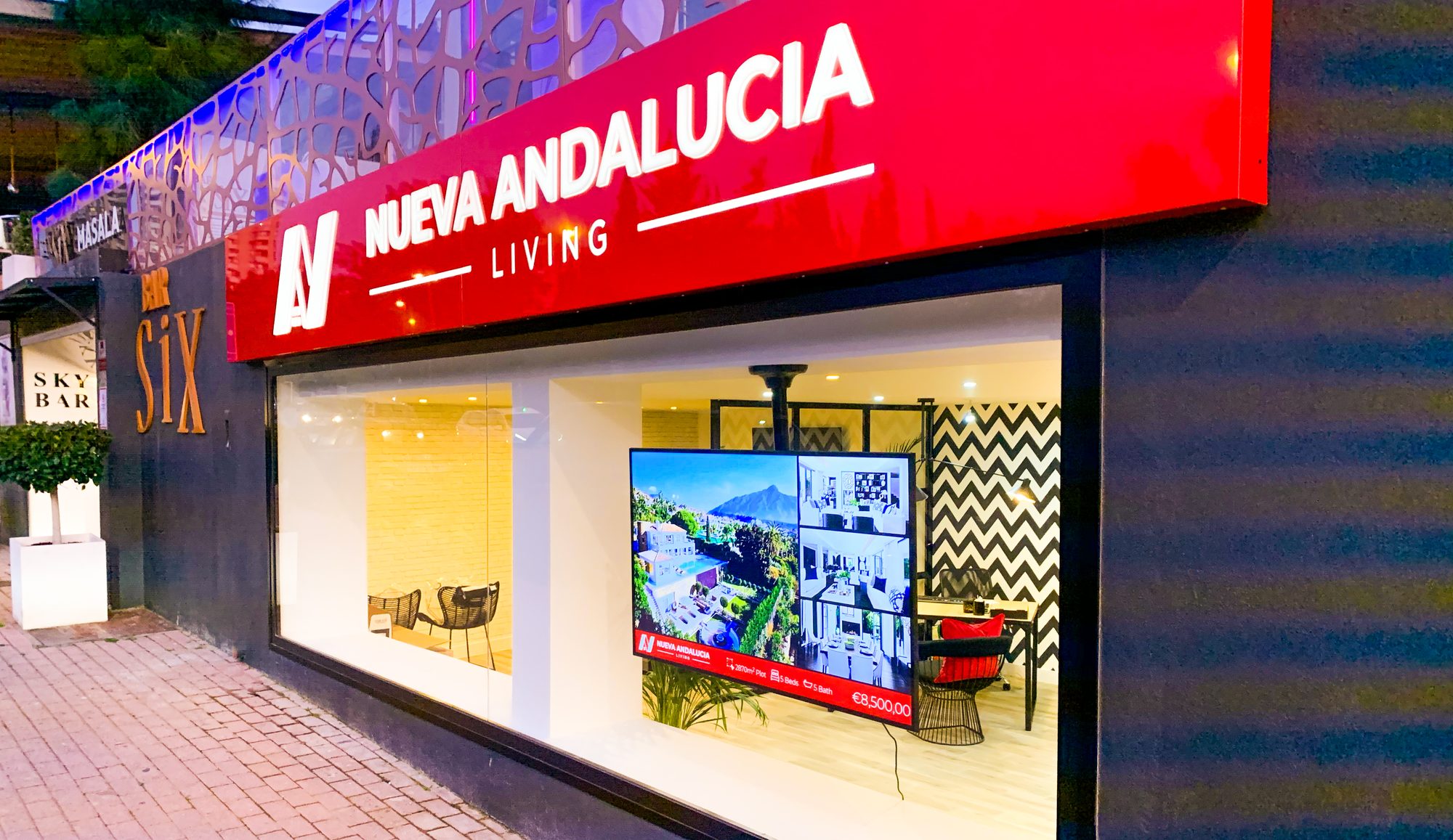 The Nueva Andalucia Living office on Avenida del Prado at dusk